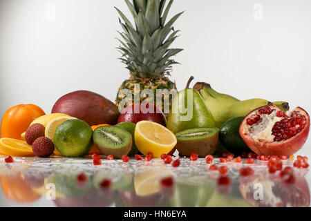 Mix di colorati frutti tropicali poste su una superficie bianca. Gocce di acqua sui frutti Foto Stock