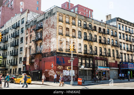 New York, Stati Uniti d'America - 18 Giugno 2016: la gente cammina accanto a vecchie e arrugginite edificio con graffiti in Chinatown in New York City Foto Stock