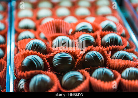 Ribbed tartufi di cioccolato in rosso pirottini di carta bicchieri liner su un vassoio Foto Stock