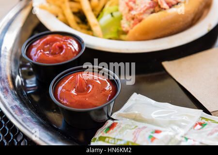 Ketchup in tazze con fast food su un vassoio Foto Stock