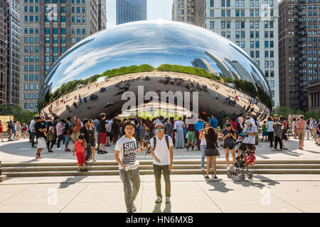 Chicago, Stati Uniti d'America - 30 Maggio 2016: Chicago bean in Millennium Park con molte persone e gli edifici in background e due giovani ragazzi di scattare una foto Foto Stock