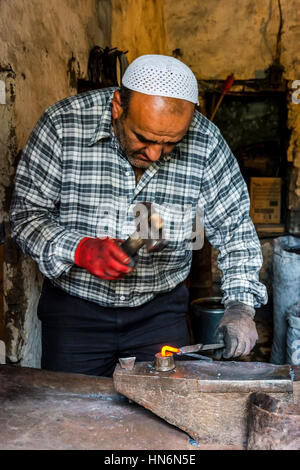LAHICH, AZERBAIGIAN - 1 ottobre: Senior fabbro rendendo i chiodi con il martello e pinze in Lahich, famoso di smith tradizione. Ottobre 2016 Foto Stock