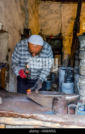LAHICH, AZERBAIGIAN - 1 ottobre: Senior fabbro rendendo i chiodi con il martello e pinze in Lahich, famoso di smith tradizione. Ottobre 2016 Foto Stock