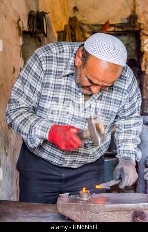 LAHICH, AZERBAIGIAN - 1 ottobre: Senior fabbro rendendo i chiodi con il martello e pinze in Lahich, famoso di smith tradizione. Ottobre 2016 Foto Stock