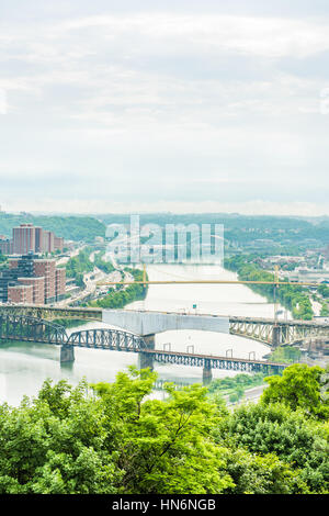 Vista verticale della città di Pittsburgh cityscape o skyline sul giorno nuvoloso con ponte della Libertà e Monongahela river Foto Stock