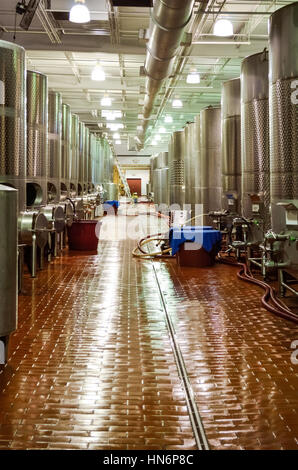 Moderna cantina fabbrica con metallo di grandi dimensioni in alluminio serbatoi di fermentazione o barili per uva da vino e pulire il pavimento piastrellato Foto Stock