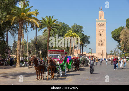 MARRAKECH, Marocco - Apr 29, 2016: carrozze trainate da cavalli in attesa intorno Moschea Koutoubia per turisti. Foto Stock