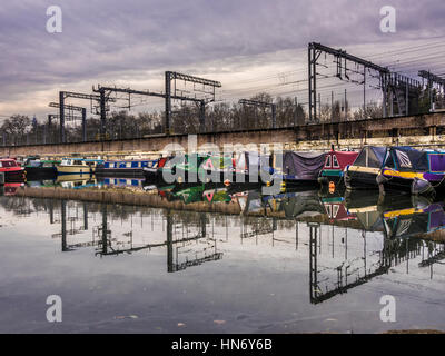 Battelli ormeggiati sul Regent's Canal con linee del treno nella stazione di St Pancras in background, Londra, Regno Unito. Foto Stock