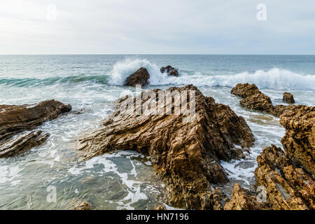 Rising Pacific surf rompe sul roccioso litorale della California Foto Stock