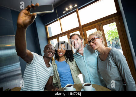 Gruppo di amici prendendo un selfie dal telefono cellulare in cafÃƒÂ© Foto Stock