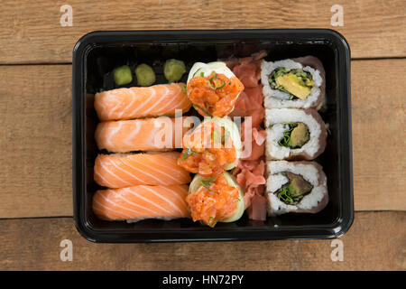 Rotoli di Sushi con salmone nel vassoio di plastica Foto Stock