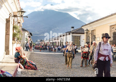 Antigua Guatemala - 15 Febbraio 2015: i turisti e i locali di passeggiata per le strade della bellissima città coloniale di Antigua in una giornata di sole. Maya donna è Foto Stock