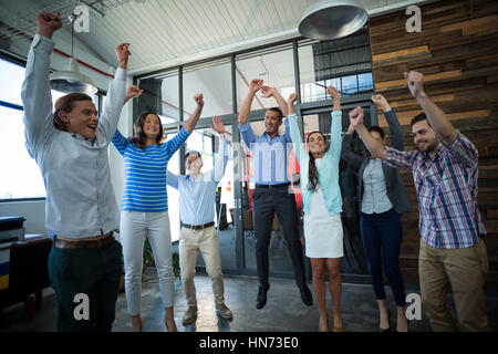 Team di entusiasti imprenditori jumping in office Foto Stock