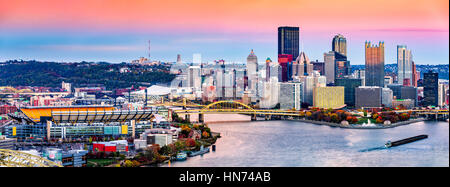 Pittsburgh, Pennsylvania skyline al tramonto e il famoso stadio di baseball di fronte fiume Allegheny Foto Stock