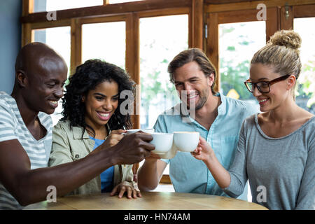 Gruppo di amici felice coppa di tostatura del caffè in cafÃƒÂ© Foto Stock