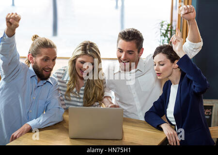 Happy amici divertendosi durante l'utilizzo di laptop in cafÃƒÂ© Foto Stock