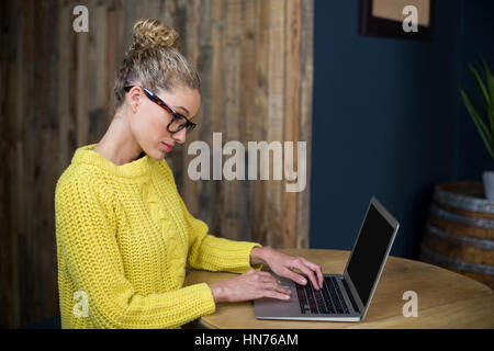 Attento bella donna seduta a tavola e Utilizzo di computer portatile in cafÃƒÂ© Foto Stock