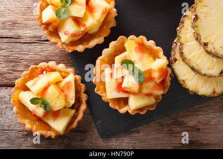 Mini crostata con ananas fresco e marmellata closeup sul tavolo. Vista orizzontale dal di sopra Foto Stock