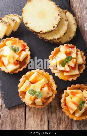 Tart riempito con ananas fresco e marmellata closeup sul tavolo. vista verticale da sopra Foto Stock