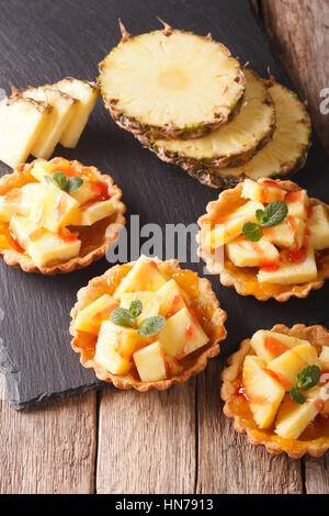 Mini crostata con ananas fresco e marmellata closeup sul piano verticale. Foto Stock