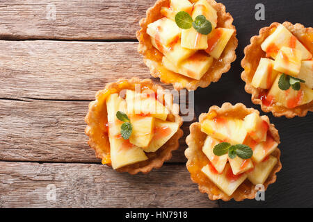 Mini crostata con ananas e menta vicino sul tavolo. vista orizzontale dal di sopra Foto Stock