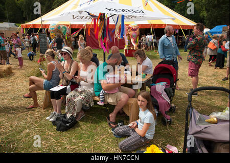 Famiglie seduti ai tavoli del cibo in stallo bere e mangiare presso il porto Eliot Festival Cornovaglia Foto Stock