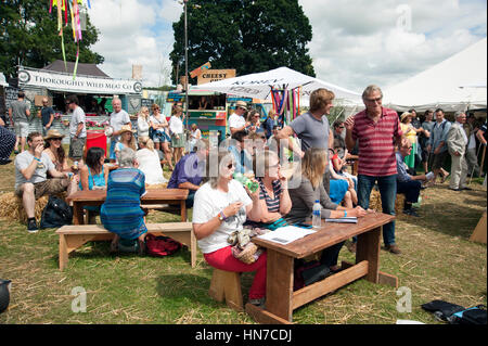 Famiglie seduti ai tavoli del cibo in stallo bere e mangiare presso il porto Eliot Festival Cornovaglia Foto Stock