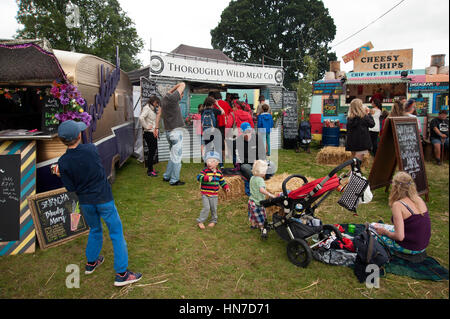 La Folla di famiglie godendo il cibo si spegne al porto Eliot Festival Cornovaglia Foto Stock