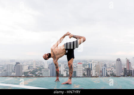 L'uomo pratica Yoga concetto sul tetto Foto Stock