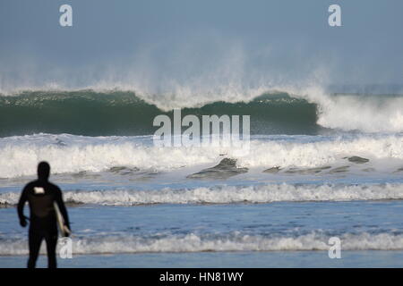 Newquay, Cornwall, Regno Unito. Il 9 febbraio, 2017. Forte offshore freddi venti soffiano indietro il high surf sulla costa nord della Cornovaglia su Fistral Beach come un surfista guarda a. Credito: Nicholas Burningham/Alamy Live News Foto Stock