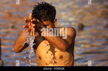 Bhaktapur, Nepal. 10 Febbraio, 2017. Un indù Nepalese devoto offre preghiere dopo assunzione di cali di santo presso il fiume Hanumante durante il Madhav Narayan festival di Bhaktapur, Nepal, il 10 febbraio, 2017. Nepalese donne Indù osservare a digiunare e pregare per la dea Swasthani e Dio Madhavnarayan per la longevità dei loro mariti e la prosperità della famiglia durante i mesi di durata del festival. Credito: Sunil Sharma/Xinhua/Alamy Live News Foto Stock