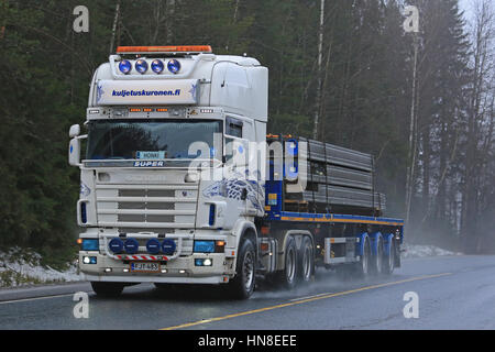 FORSSA, Finlandia - 28 gennaio 2017: Bianco personalizzato Super Scania semi di Autopalvelu D. Kuronen cale travi di cemento lungo la strada bagnata su un nebbioso giorno in Foto Stock