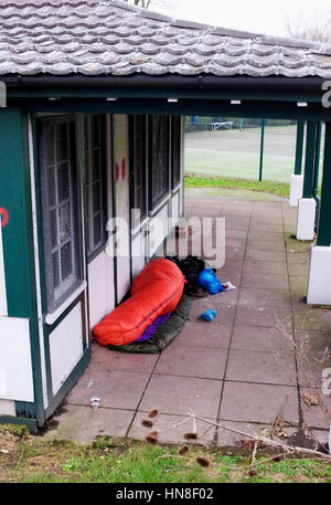 Senzatetto traversina ruvida si rifugiano presso il Queens Park Tennis Club Pavilion a Brighton Regno Unito fotografia scattata da Simon Dack Foto Stock