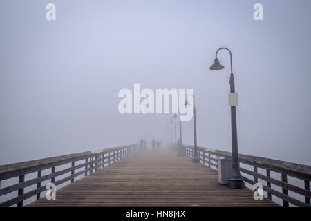 Sagome di persone nella nebbia sull'Imperial Beach Pier. Foto Stock