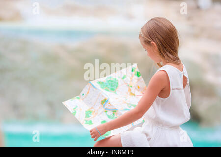 Adorabile ragazza guardando mappa turistica vicino a Fontana di Trevi a Roma. Felice toodler kid godere di vacanza italiana in Europa. Foto Stock