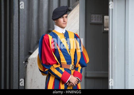 Roma, Italia- una guardia svizzera in piedi all'ingresso della nuova Basilica di San Pietro si trova nella Città del Vaticano (un enclave di Roma). Iniziato da papa Giulio I Foto Stock