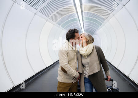 Coppia senior nel corridoio della metropolitana tirando trolley. Foto Stock