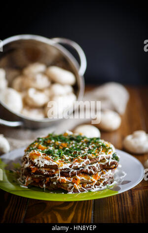 Torta di fegato ripieno di verdure al buio su un tavolo di legno Foto Stock