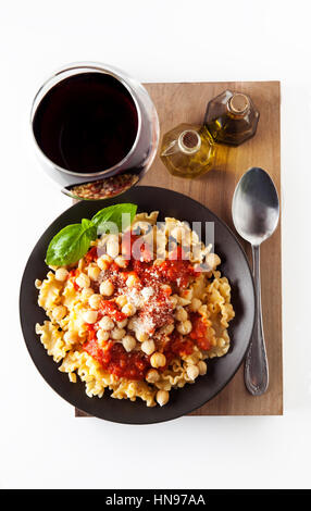 Pasta Vegetariana con salsa di pomodoro e i ceci e vino rosso. idea per il pranzo o la cena Foto Stock