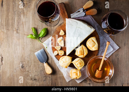 Il piatto di formaggi assortimento di vari tipi di formaggio e miele sul tagliere di legno Foto Stock