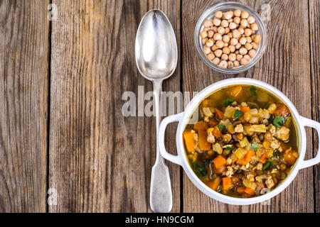 Zuppa piccante con i ceci, la zucca e il curry in una ciotola bianco su Foto Stock
