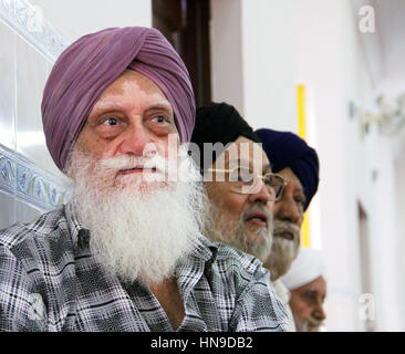 Un anziano uomo di Sikh indiano con una barba lunga bianca che indossa un turbante con il disordine della pelle di vitiligo ad un matrimonio di Sikh in Malesia Foto Stock