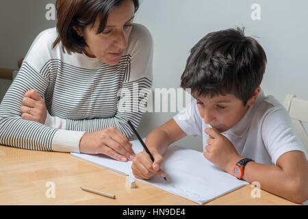 Madre aiuta a 9 anno di età scolaro con compiti,UK Foto Stock