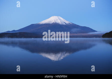 Vista notturna di cielo nuvoloso e il Monte Fuji di notte dal lago Yamanaka, Prefettura di Yamanashi, Giappone Foto Stock