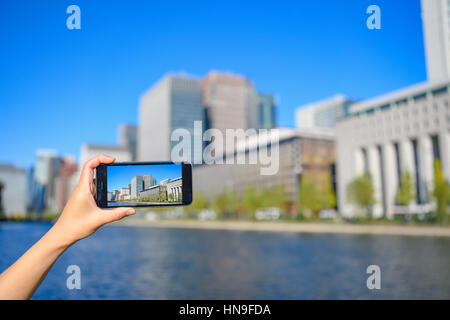 Donna Giapponese utilizzando augumented reality app sullo smartphone centro di Tokyo, Giappone Foto Stock