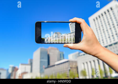 Donna Giapponese utilizzando augumented reality app sullo smartphone centro di Tokyo, Giappone Foto Stock