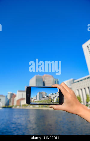 Donna Giapponese utilizzando augumented reality app sullo smartphone centro di Tokyo, Giappone Foto Stock