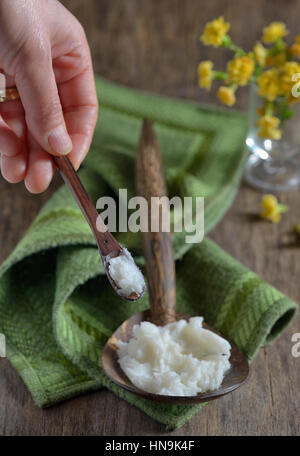 Olio di noce di cocco sul cucchiaio di legno Foto Stock