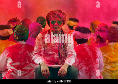 Giovani indiani uomini seduti, coperto di polvere colorata durante Holi festival a colori Foto Stock