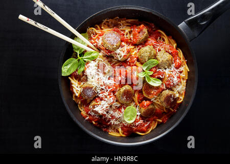 Gli spaghetti e polpette vegetariane da lenticchie , di patate e formaggio parmigiano e salsa di soia bolognese . su una padella. bacchette. comfort italiano cibo sano Foto Stock